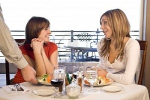 friends-sitting-at-a-table-having-lunch-being-served-salad
